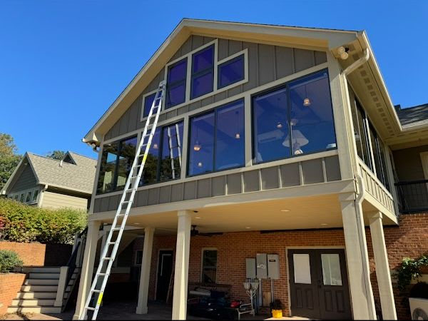 Lake home with tall gable windows and ladders set up
